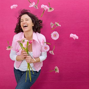 spring concept - playful girls with flowers and pink wall