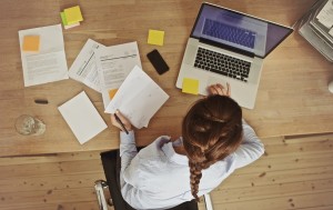 Businesswoman Working At Her Office Desk With Documents And Lapt