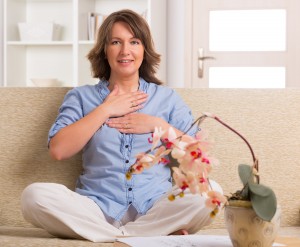 Woman practicing self Reiki transfering energy through palms, a